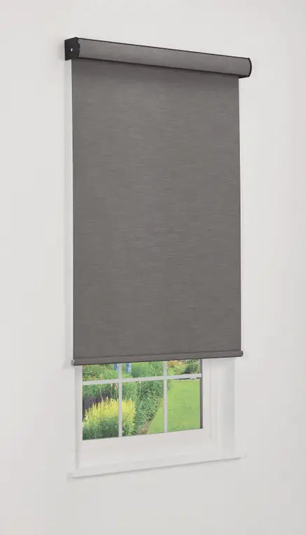Mojave blackout roller shade outside mounted above a window overlooking a garden